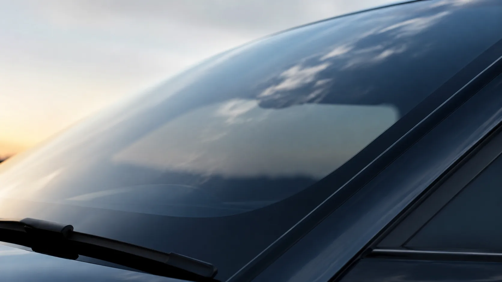 Crystal-clear replacement windshield reflecting the evening sky